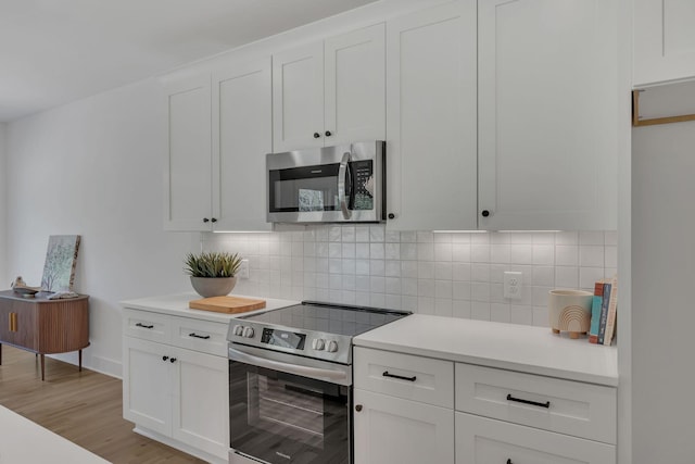 kitchen featuring light countertops, backsplash, white cabinetry, and appliances with stainless steel finishes