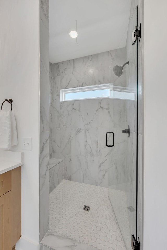 bathroom with a marble finish shower and vanity