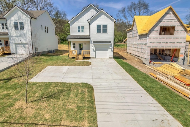 traditional-style house featuring concrete driveway, a front yard, board and batten siding, and a garage
