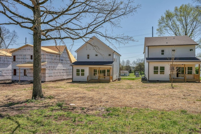 back of property featuring a yard and covered porch