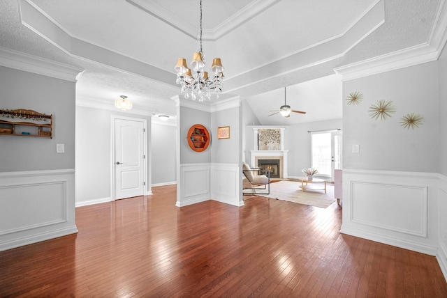 580 Mountain View Dr, Clarksville, TN 37043 - unfurnished dining area featuring a warm lit fireplace, wainscoting, a decorative wall, wood-type flooring, and ceiling fan with notable chandelier