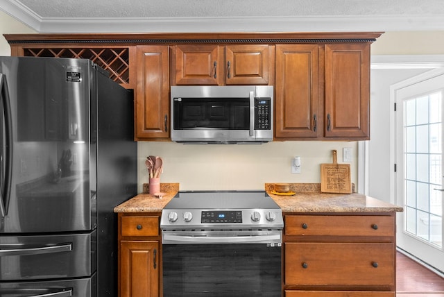 580 Mountain View Dr, Clarksville, TN 37043 - kitchen featuring brown cabinetry, plenty of natural light, ornamental molding, and appliances with stainless steel finishes