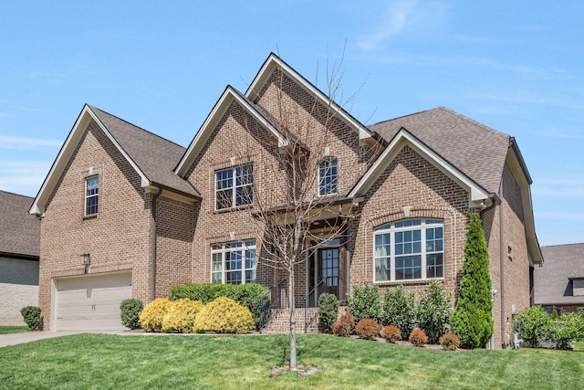 1009 Alpaca Dr, Spring Hill, TN 37174 - traditional-style home featuring brick siding, a front yard, a shingled roof, and a garage