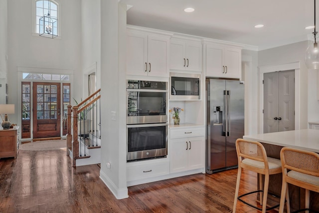 1009 Alpaca Dr, Spring Hill, TN 37174 - kitchen with stainless steel appliances, dark wood-style flooring, white cabinetry, and light countertops