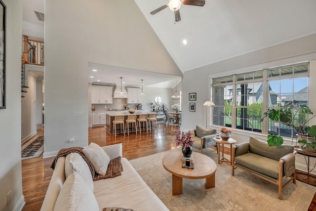 1009 Alpaca Dr, Spring Hill, TN 37174 - living room with baseboards, light wood-style flooring, a ceiling fan, crown molding, and high vaulted ceiling