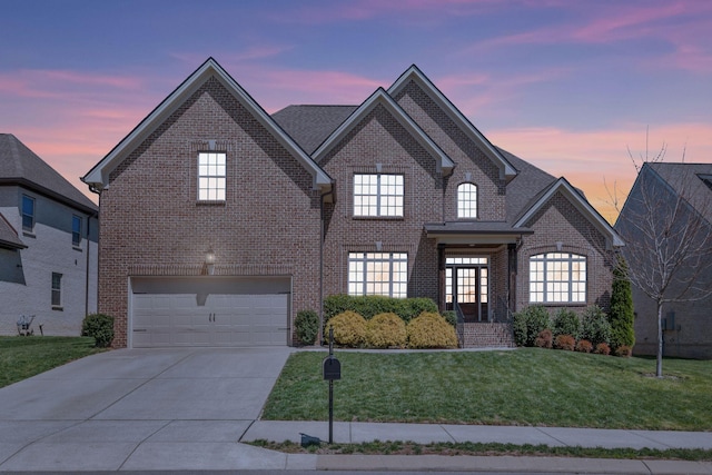 1009 Alpaca Dr, Spring Hill, TN 37174 - french country home featuring concrete driveway, a front yard, brick siding, and an attached garage
