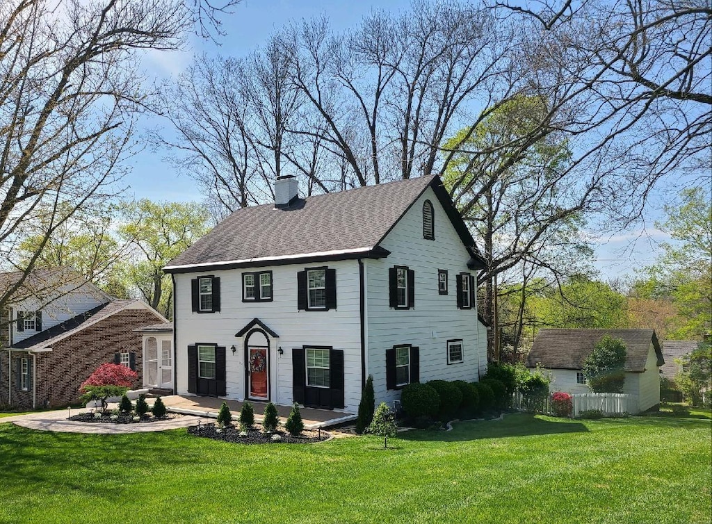 123 W Glenwood Dr, Clarksville, TN 37040 - colonial-style house with a chimney, a shingled roof, and a front lawn