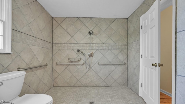 bathroom with toilet and tiled shower