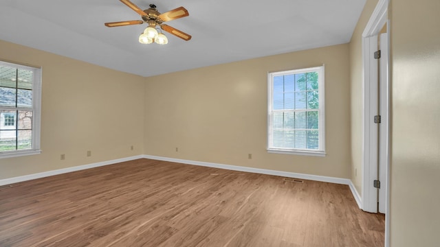 spare room featuring light wood finished floors, baseboards, and ceiling fan