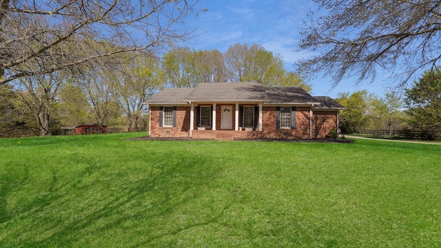 view of front of house with a front yard, brick siding, and fence