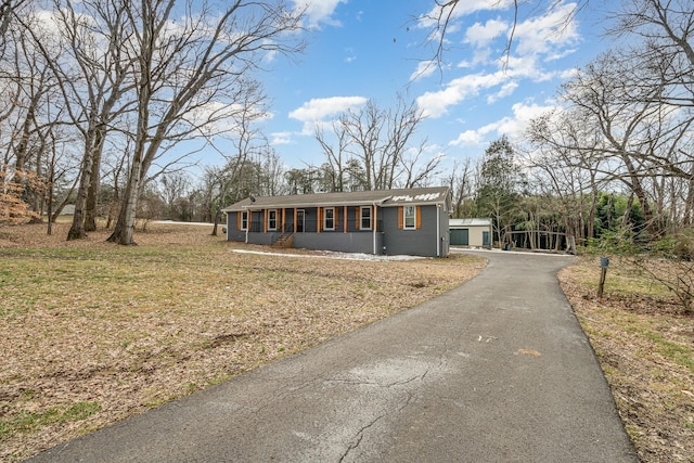 view of front of house with concrete block siding and a front lawn