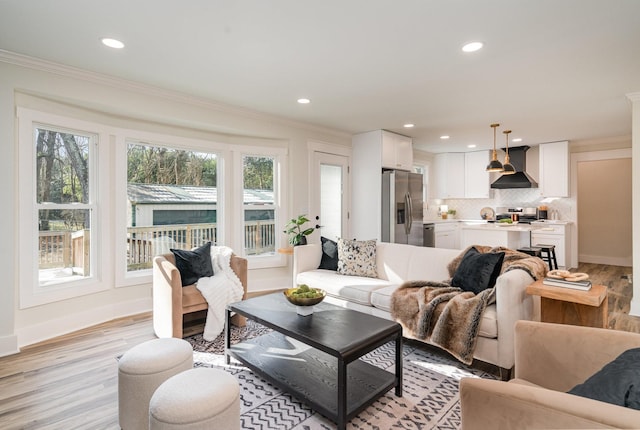 living room with ornamental molding, light wood-style flooring, recessed lighting, and baseboards