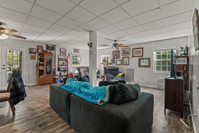 living room featuring a drop ceiling, a ceiling fan, and visible vents