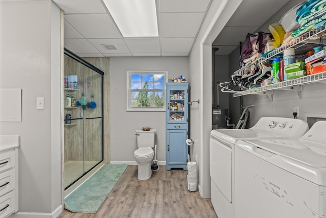 washroom with visible vents, baseboards, washer and dryer, laundry area, and light wood-style flooring
