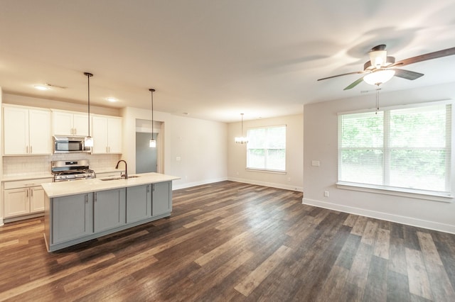224 Griffin Ln, Gallatin, TN 37066 - kitchen with baseboards, appliances with stainless steel finishes, gray cabinetry, ceiling fan with notable chandelier, and dark wood-type flooring