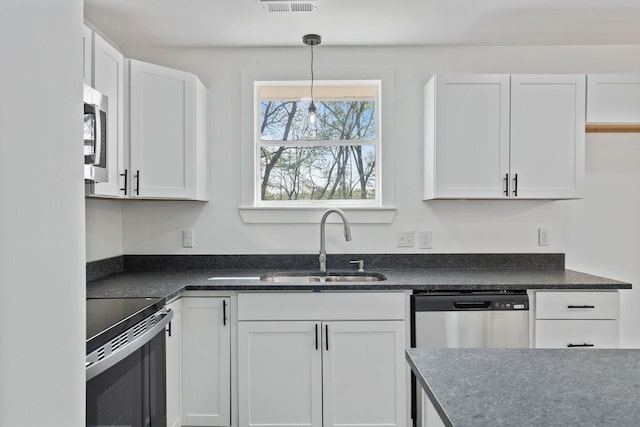 kitchen with hanging light fixtures, visible vents, a sink, appliances with stainless steel finishes, and white cabinetry