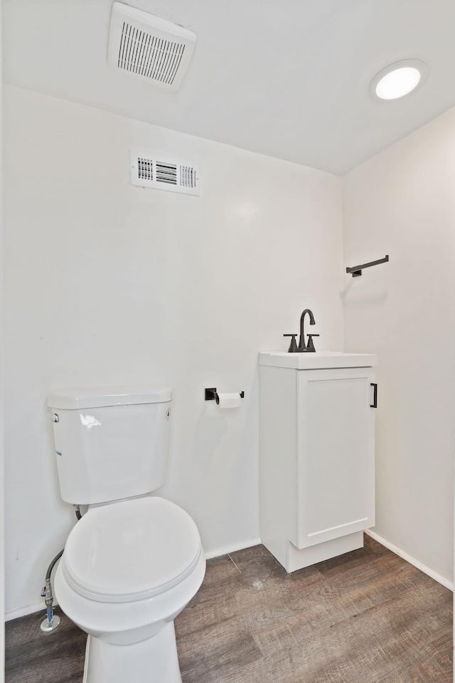 bathroom featuring toilet, baseboards, a sink, and visible vents