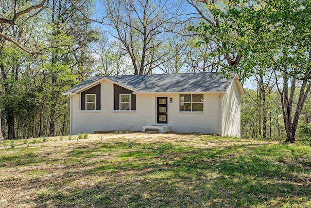single story home featuring a front yard and brick siding