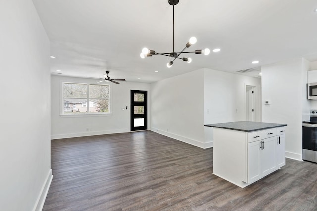 kitchen with dark countertops, visible vents, dark wood-style flooring, and appliances with stainless steel finishes