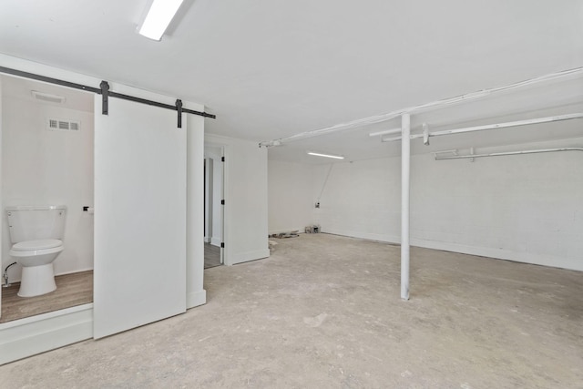 below grade area featuring a barn door and visible vents