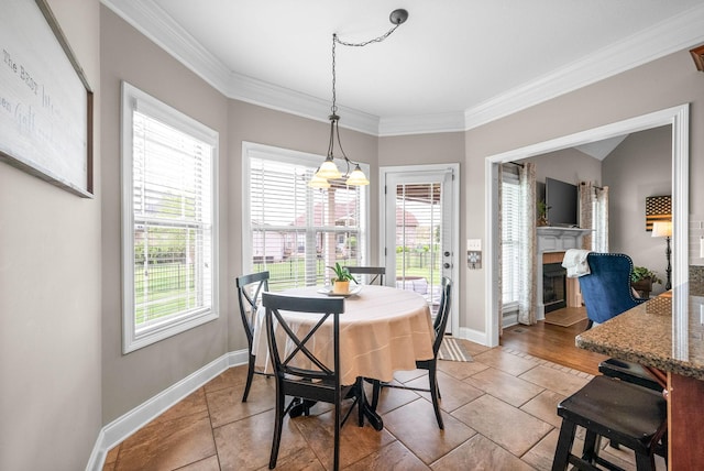 dining area featuring crown molding, a fireplace, and baseboards