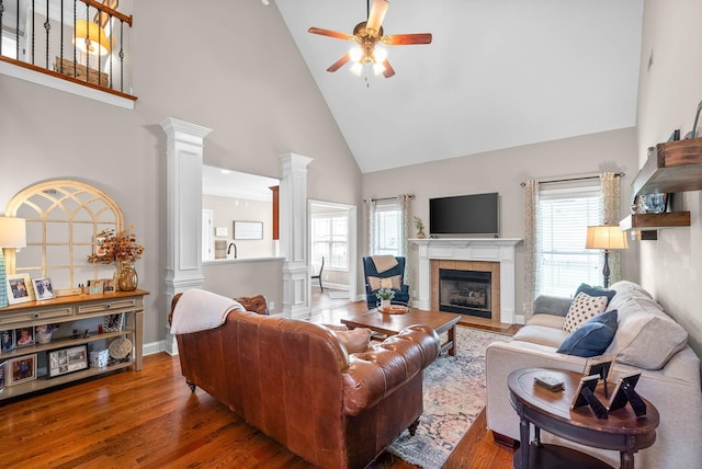 living area with ornate columns, a healthy amount of sunlight, high vaulted ceiling, and ceiling fan