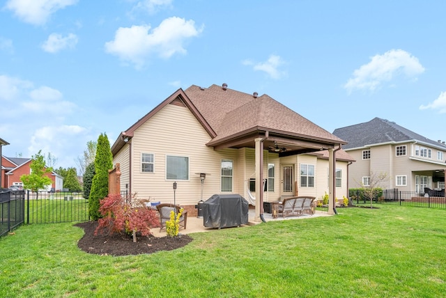 back of property with a patio area, roof with shingles, a yard, and a fenced backyard