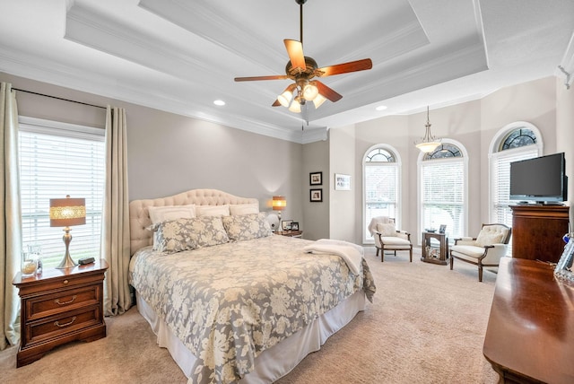 bedroom featuring crown molding, a tray ceiling, and light colored carpet