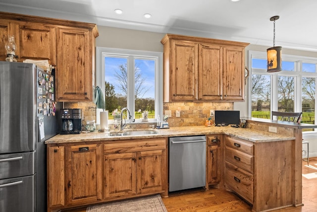 113 St Charles Way, Gallatin, TN 37066 - kitchen featuring appliances with stainless steel finishes, a peninsula, a sink, brown cabinets, and backsplash
