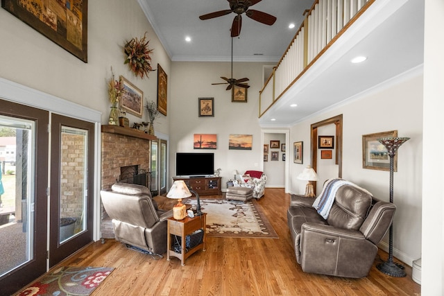 113 St Charles Way, Gallatin, TN 37066 - living area featuring a ceiling fan, wood finished floors, a stone fireplace, ornamental molding, and a towering ceiling