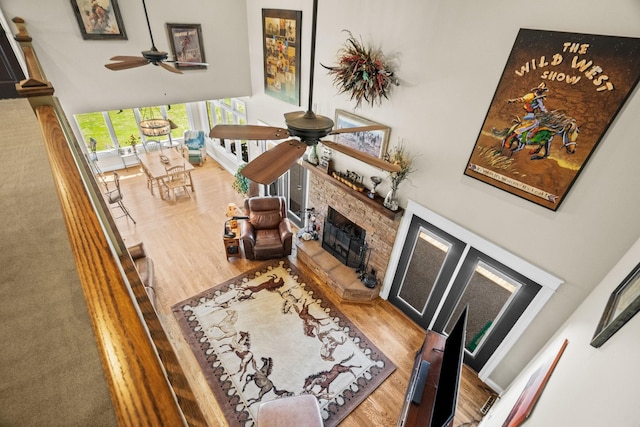 113 St Charles Way, Gallatin, TN 37066 - living room with ceiling fan, a fireplace with raised hearth, a towering ceiling, and wood finished floors