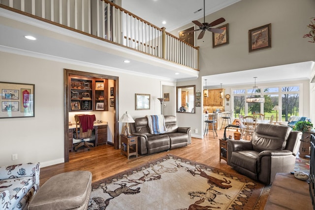 113 St Charles Way, Gallatin, TN 37066 - living room with a high ceiling, crown molding, baseboards, light wood-style floors, and a ceiling fan