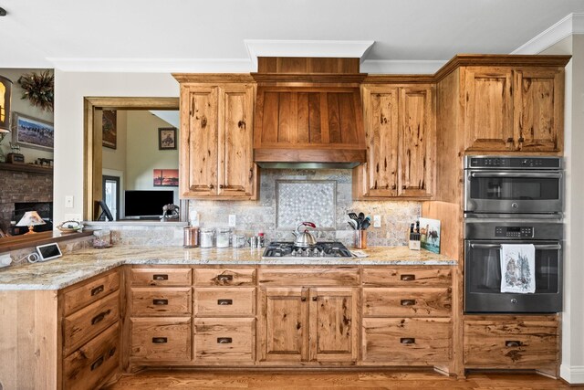 113 St Charles Way, Gallatin, TN 37066 - kitchen featuring multiple ovens, light stone counters, decorative backsplash, crown molding, and light wood finished floors