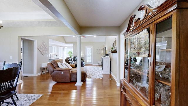 interior space with light wood-style flooring, decorative columns, and baseboards