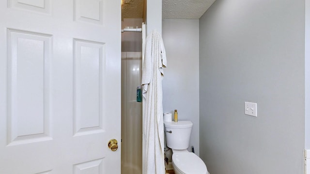 bathroom with toilet and a textured ceiling
