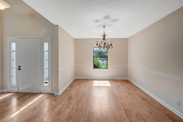 308 Wareham Ct, Antioch, TN 37013 - foyer with a chandelier, light wood-style floors, baseboards, and a textured ceiling
