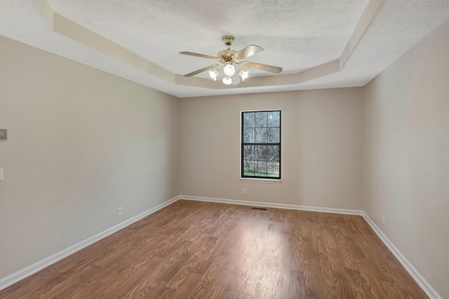 308 Wareham Ct, Antioch, TN 37013 - empty room with a raised ceiling, a textured ceiling, wood finished floors, and ceiling fan