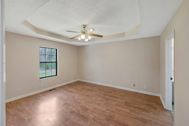 308 Wareham Ct, Antioch, TN 37013 - unfurnished room with a tray ceiling, light wood-style floors, and a textured ceiling