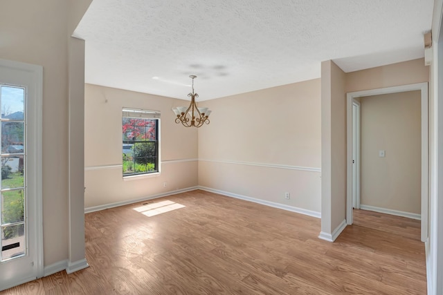 308 Wareham Ct, Antioch, TN 37013 - unfurnished dining area with light wood-style flooring, a notable chandelier, baseboards, and a textured ceiling