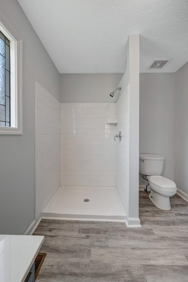308 Wareham Ct, Antioch, TN 37013 - bathroom featuring visible vents, a tile shower, toilet, and wood finished floors