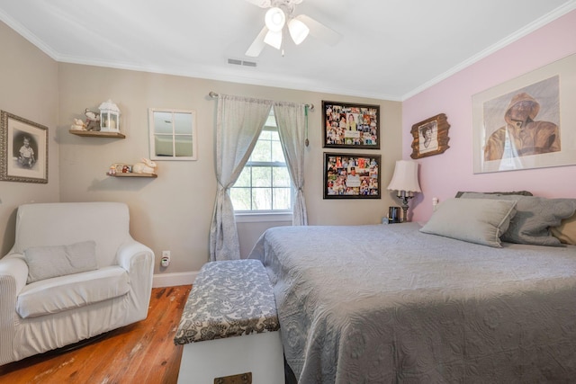 bedroom featuring crown molding, wood finished floors, baseboards, and visible vents