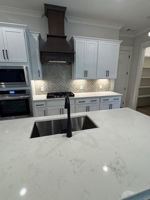 5818 Willoughby Way, Murfreesboro, TN 37129 - kitchen featuring appliances with stainless steel finishes, premium range hood, crown molding, light stone counters, and tasteful backsplash