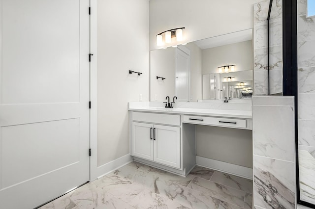 bathroom featuring baseboards, marble finish floor, and vanity