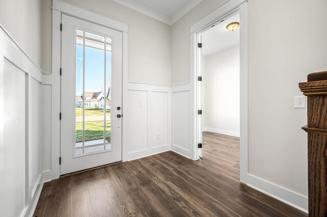entryway featuring crown molding, a decorative wall, and dark wood-style floors