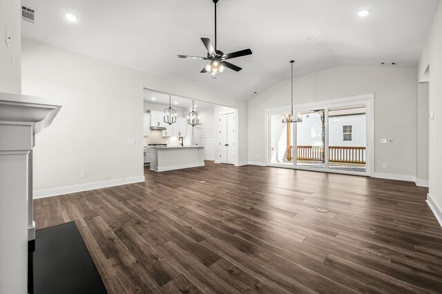 unfurnished living room featuring visible vents, dark wood-type flooring, ceiling fan with notable chandelier, and lofted ceiling