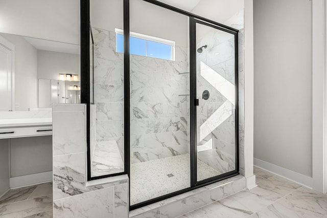 full bath featuring vanity, marble finish floor, baseboards, and a marble finish shower