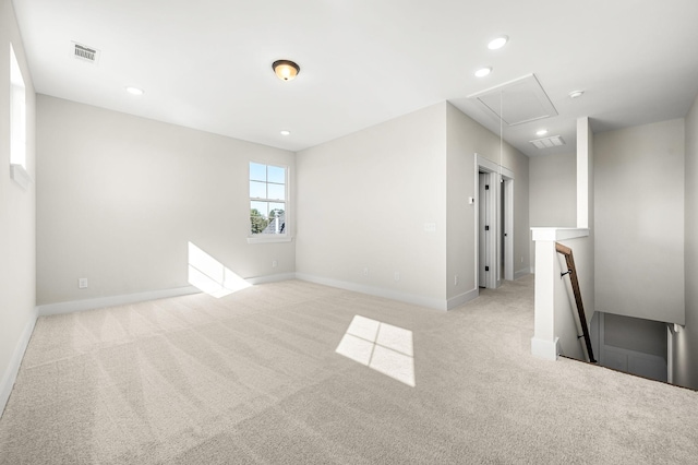 empty room featuring carpet floors, attic access, recessed lighting, baseboards, and visible vents