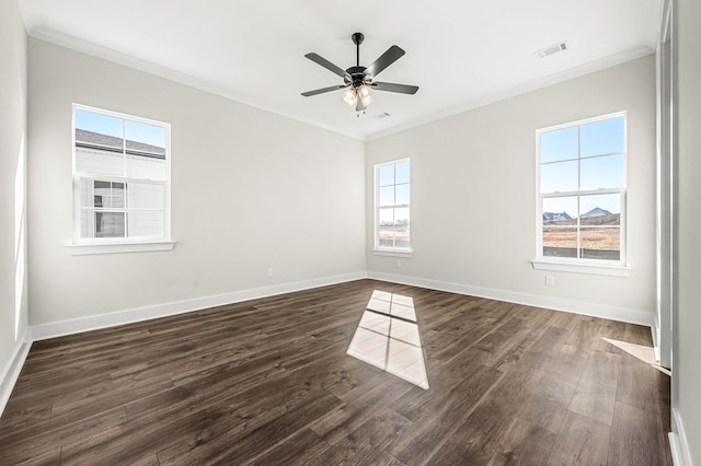 spare room featuring a ceiling fan, visible vents, baseboards, ornamental molding, and dark wood-type flooring