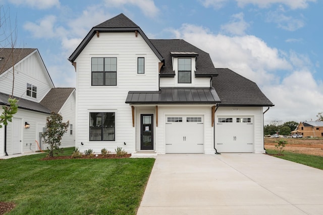 modern farmhouse with a shingled roof, a garage, a front yard, concrete driveway, and a standing seam roof