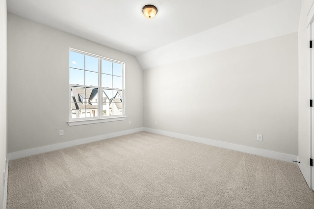 empty room with baseboards, carpet, and lofted ceiling
